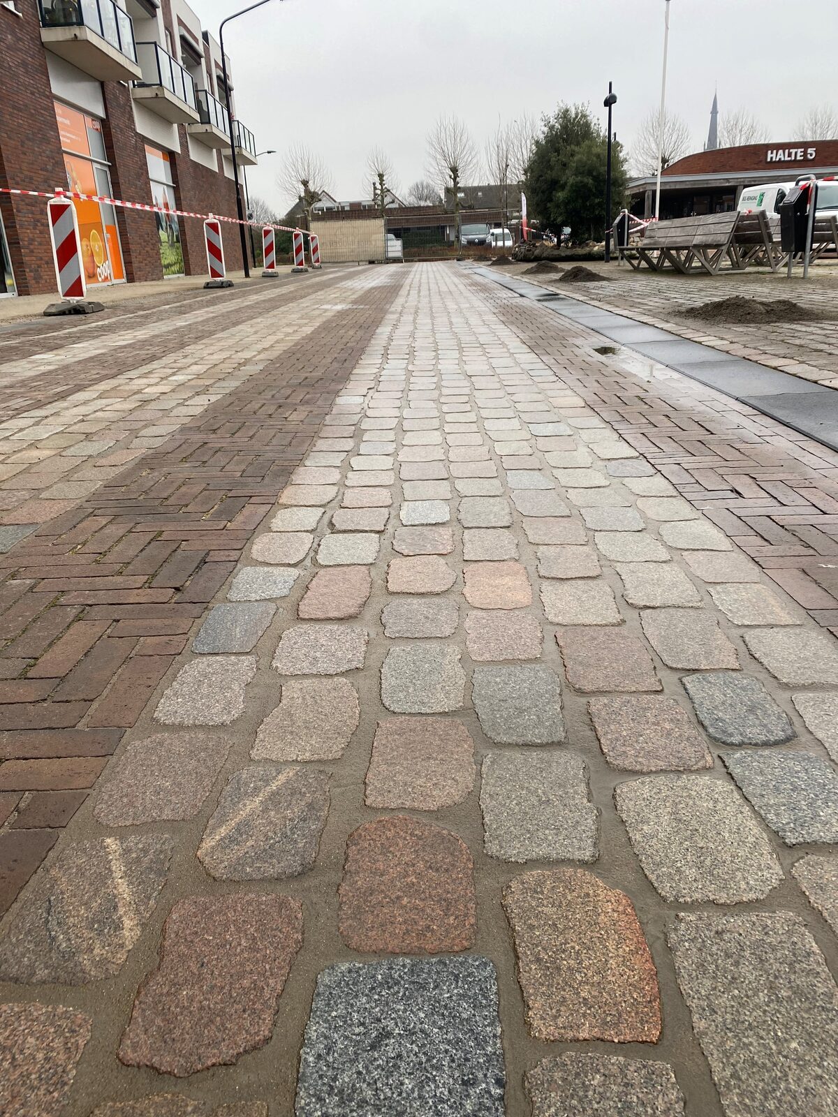 Openbare bestrating van natuursteen keien gereinigd en onkruidvrij ingevoegd. na reinigen en invoegen
